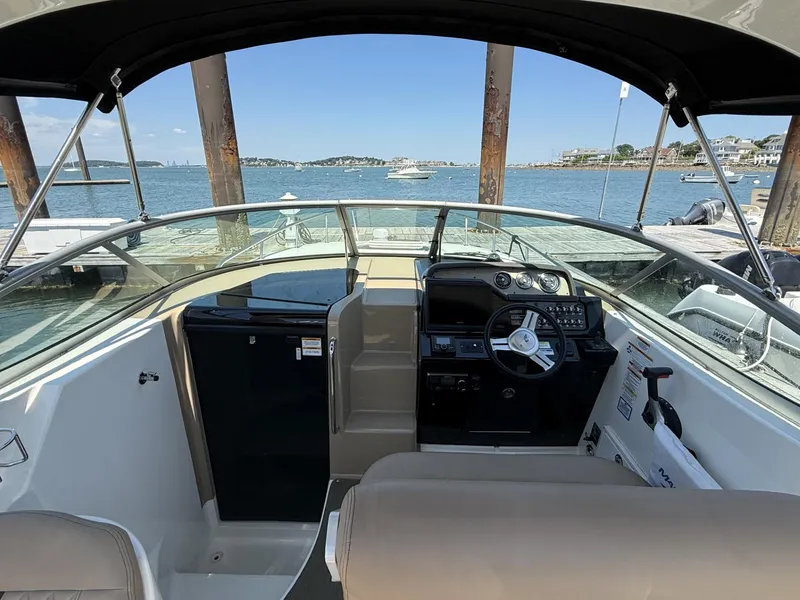 Slide: The Image of 2017 Sea Ray Sundancer 280 cockpit with steering wheel, dashboard, and waterfront view. - 9