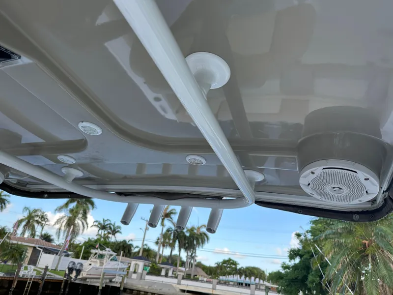 Slide: The Image of 2017 NauticStar 2602 Legacy boat roof with rod holders and speaker, dockside view. - 11