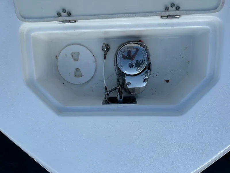 Slide: The Image of Anchor compartment of 2017 NauticStar 2602 Legacy boat, featuring a winch and storage space. - 13
