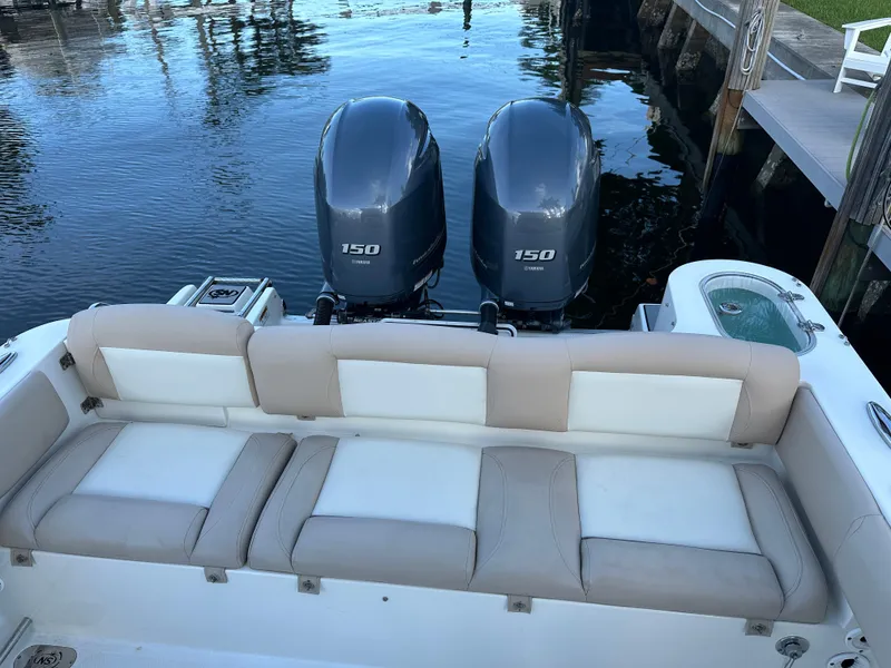 Slide: The Image of 2017 NauticStar 2602 Legacy boat with twin Yamaha 150 engines, docked by the water. - 6