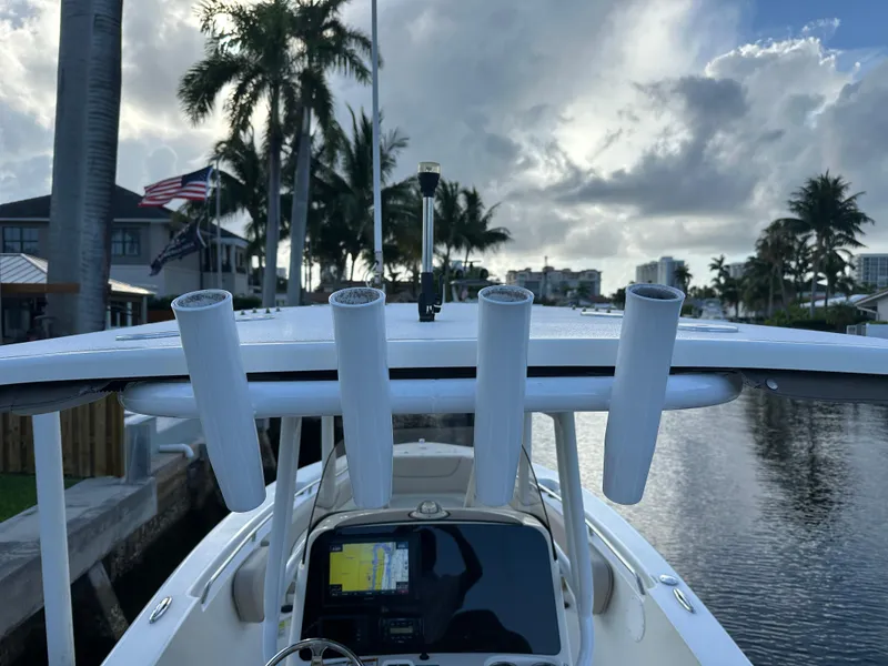 Slide: The Image of 2017 NauticStar 2602 Legacy boat docked, featuring rod holders and a navigation system. - 7