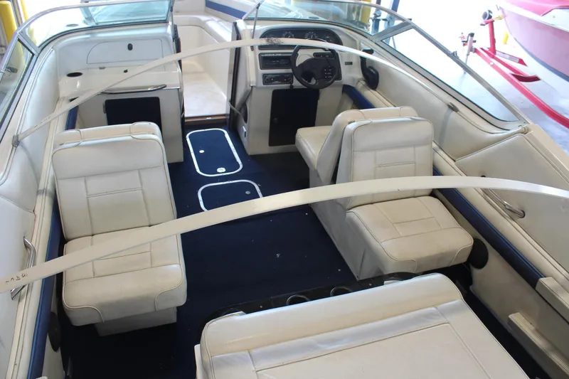 Slide: The Image of Interior of a 1994 Celebrity 230 BR boat with white seating and blue carpet. - 12