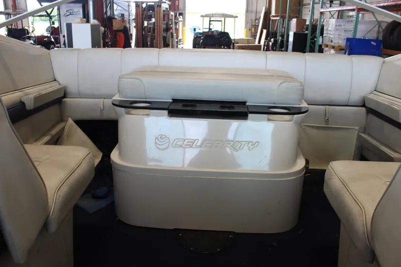 Slide: The Image of Interior of a 1994 Celebrity 230 BR boat with white seating and storage. - 17