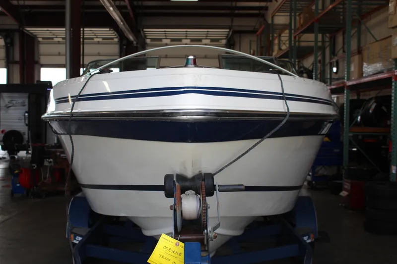 Slide: The Image of 1994 Celebrity 230 BR boat in a warehouse on a trailer. - 2