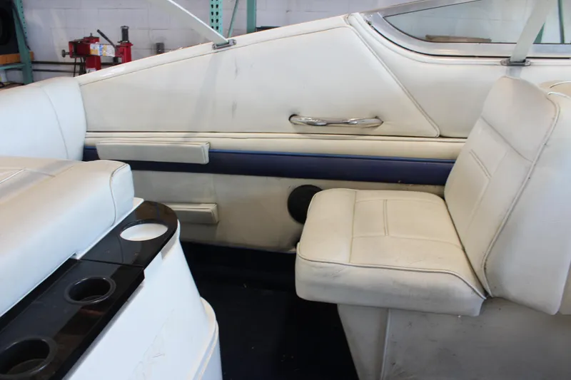 Slide: The Image of Interior of a 1994 Celebrity 230 BR boat with white seating and cup holders. - 20