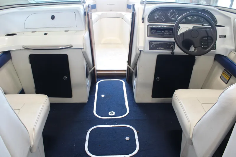 Slide: The Image of Interior of a 1994 Celebrity 230 BR boat with white seating and blue carpet. - 22
