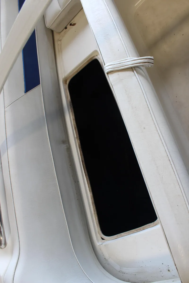 Slide: The Image of White interior of a 1994 Celebrity 230 BR boat, featuring a storage compartment. - 30