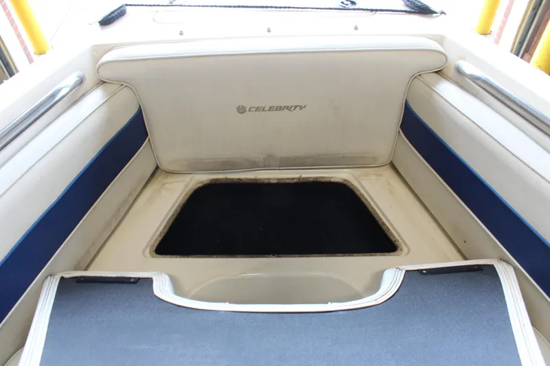 Slide: The Image of 1994 Celebrity 230 BR boat interior with seating and storage compartment. - 32