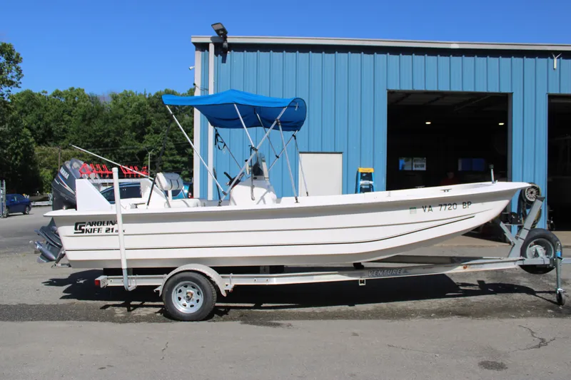 Slide: The Image of 2010 Carolina Skiff 2180 DLX boat on trailer with blue canopy. - 0