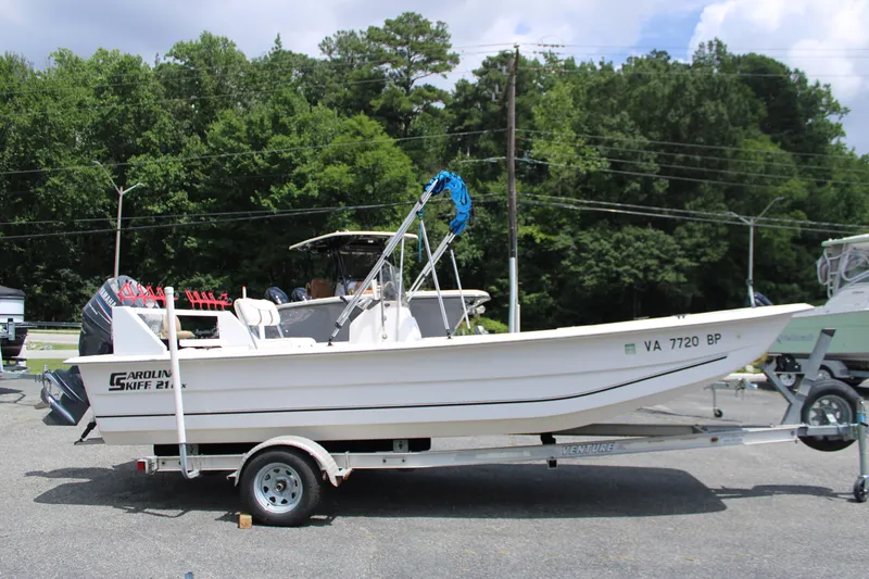 Slide: The Image of 2010 Carolina Skiff 2180 DLX boat on trailer, parked outdoors. - 11