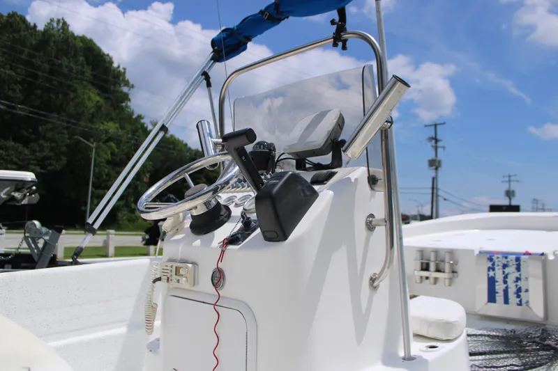 Slide: The Image of 2010 Carolina Skiff 2180 DLX boat console with steering wheel and controls under blue sky. - 13