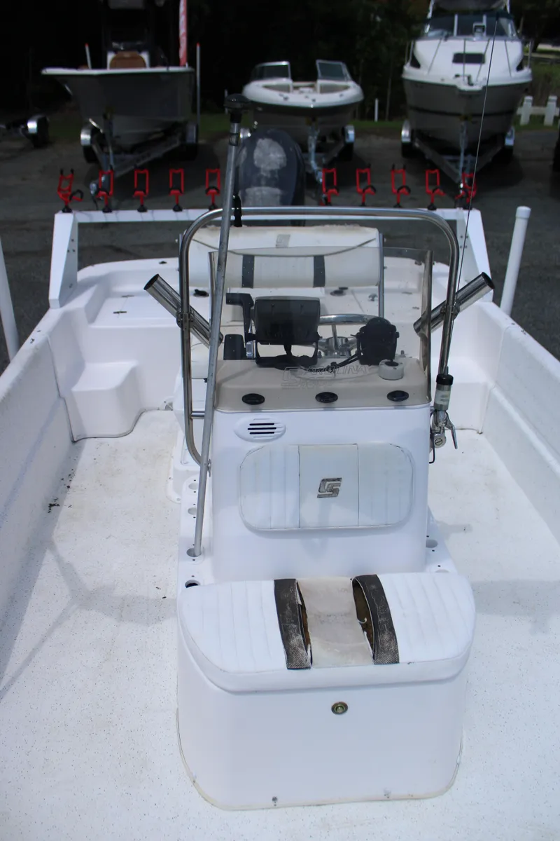 Slide: The Image of 2010 Carolina Skiff 2180 DLX boat interior with center console and rod holders. - 14