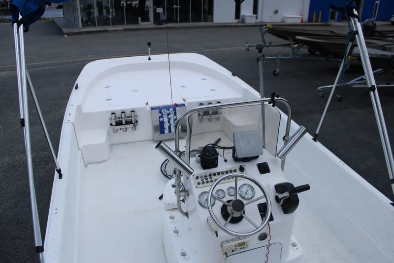 Slide: The Image of 2010 Carolina Skiff 2180 DLX boat interior with steering console and fishing rod holders. - 19