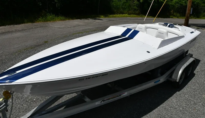 Slide: The Image of 2007 Donzi Carol Shelby 22 Classic boat on trailer, featuring sleek white design with blue stripes. - 2