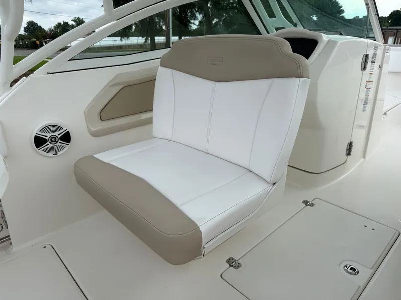 Slide: The Image of 2018 Robalo R247 Dual Console boat interior with white and beige seating. - 14
