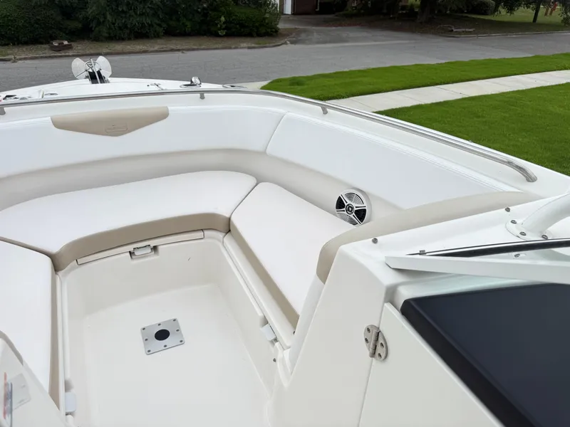 Slide: The Image of 2018 Robalo R247 Dual Console boat interior with white seating and speaker. - 19