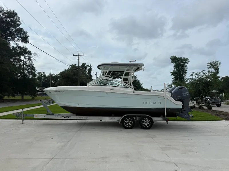 Slide: The Image of 2018 Robalo R247 Dual Console boat on trailer, parked outdoors. - 3
