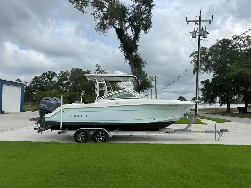 Slide: The Image of 2018 Robalo R247 Dual Console boat on trailer, parked outdoors. - 5