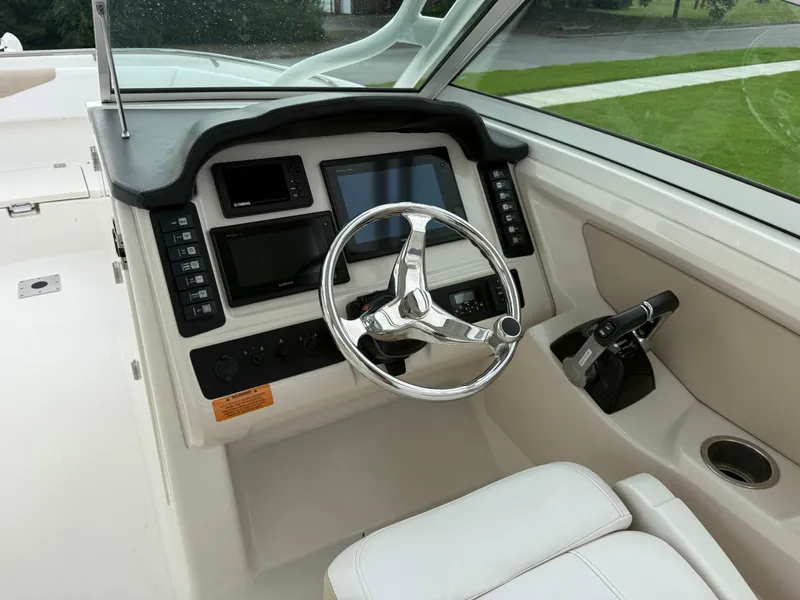 Slide: The Image of 2018 Robalo R247 Dual Console boat dashboard with steering wheel and controls. - 7