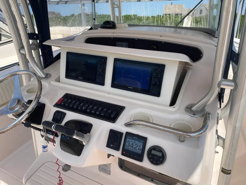 Slide: The Image of 2006 Grady-White Bimini 306 boat dashboard with navigation screens and controls. - 11