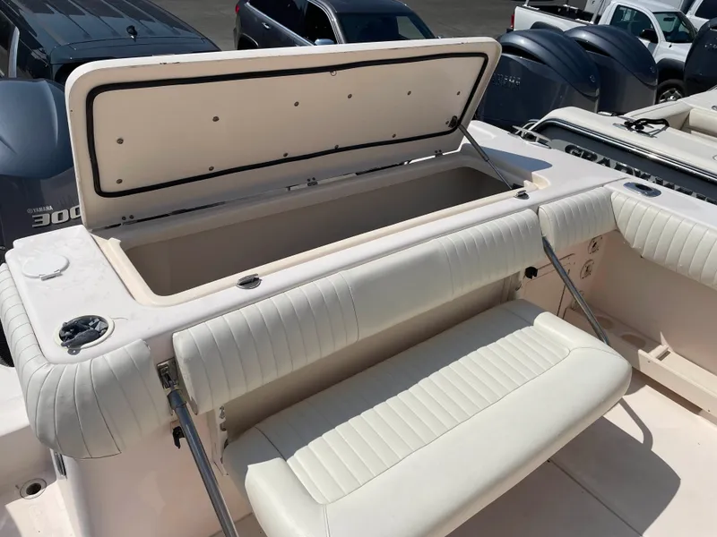 Slide: The Image of 2006 Grady-White Bimini 306 boat with open storage compartment and cushioned seating. - 14
