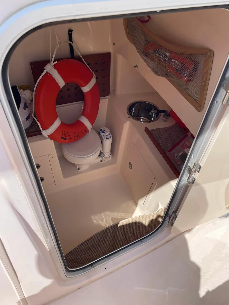 Slide: The Image of 2006 Grady-White Bimini 306 boat cabin with toilet, sink, and life preserver. - 16