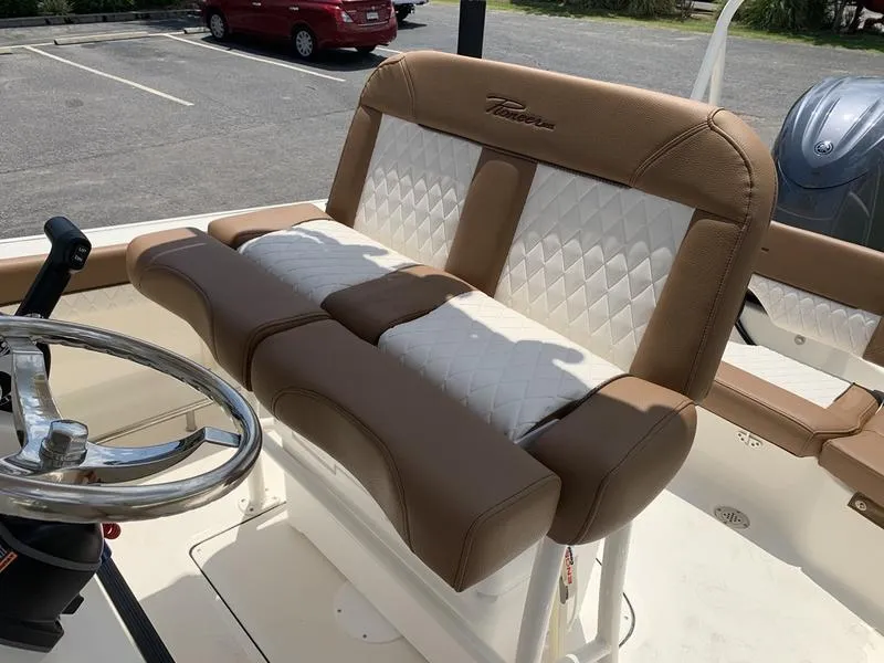 Slide: The Image of 2026 Pioneer ISLANDER 202 boat interior with tan and white seating, steering wheel visible. - 12