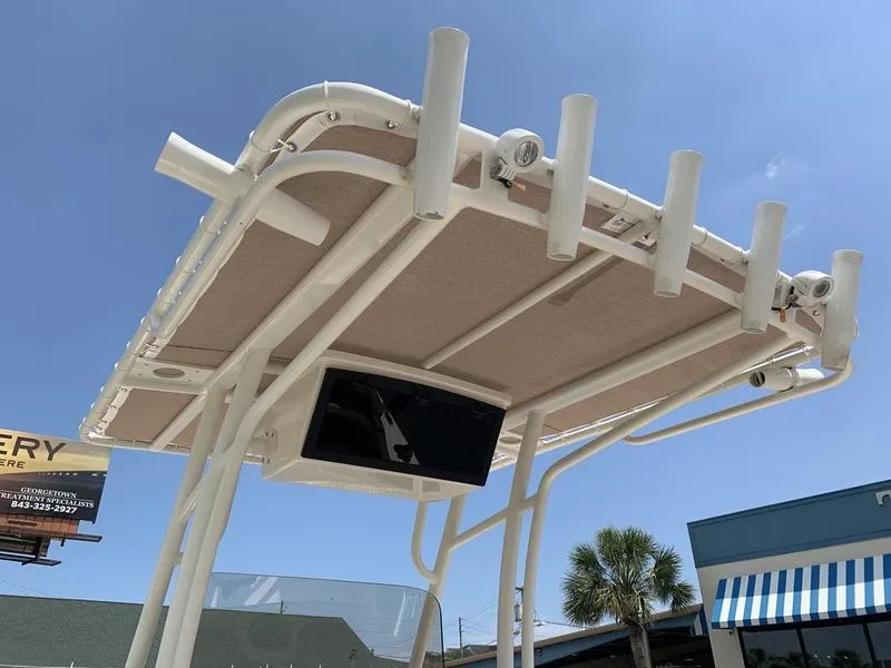 Slide: The Image of T-top of 2026 Pioneer ISLANDER 202 boat with rod holders and electronics, under clear sky. - 13