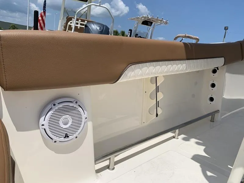 Slide: The Image of 2026 Pioneer ISLANDER 202 boat interior with brown seating and speaker. - 21