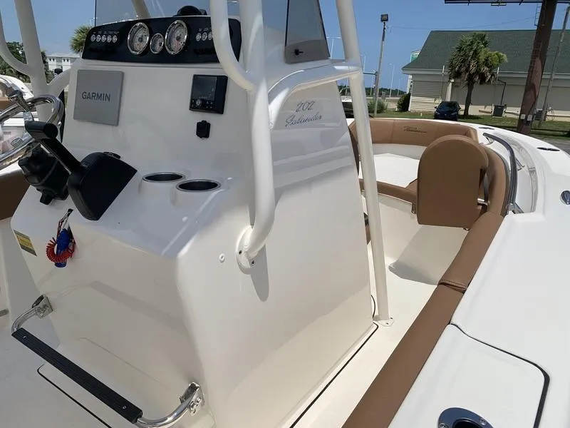 Slide: The Image of 2026 Pioneer ISLANDER 202 boat interior with Garmin equipment and brown seating. - 22