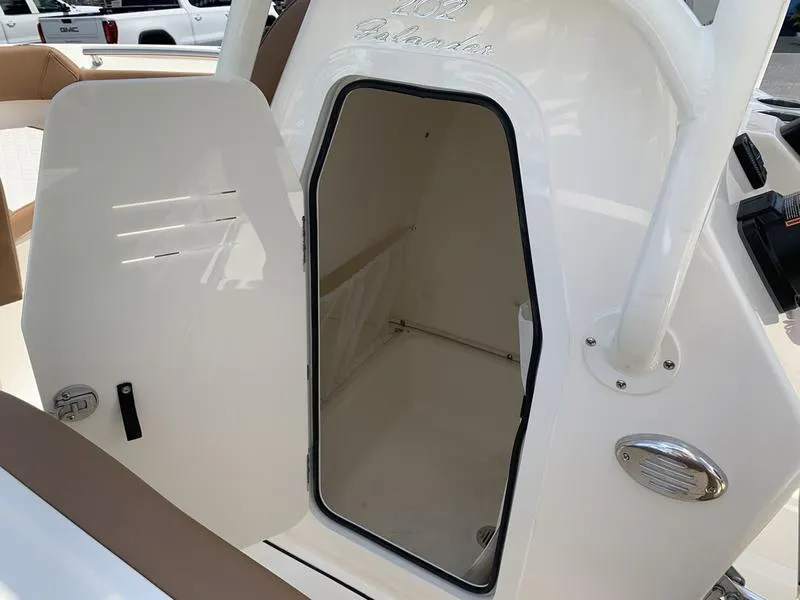 Slide: The Image of 2026 Pioneer ISLANDER 202 boat storage compartment with open door, showcasing interior space. - 24