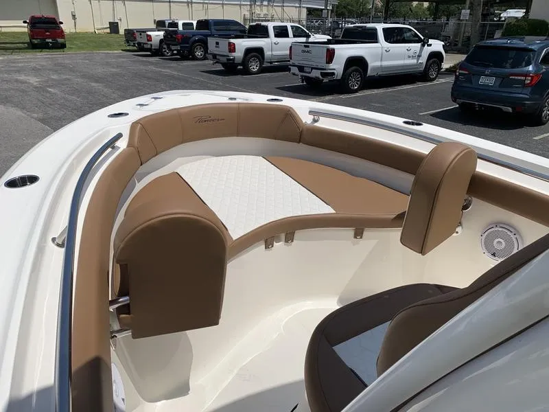 Slide: The Image of 2026 Pioneer ISLANDER 202 boat interior with tan and white seating in a parking lot. - 25