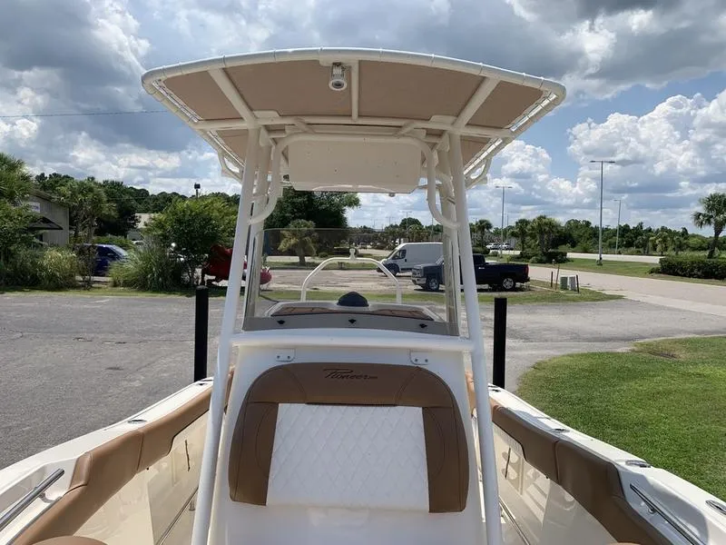 Slide: The Image of 2026 Pioneer ISLANDER 202 boat with canopy, parked outdoors under cloudy sky. - 27