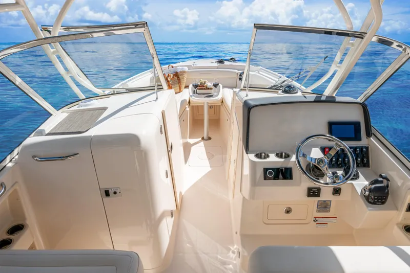 Slide: The Image of 2026 Grady-White Freedom 285 boat interior with steering wheel, ocean view, and open deck. - 7