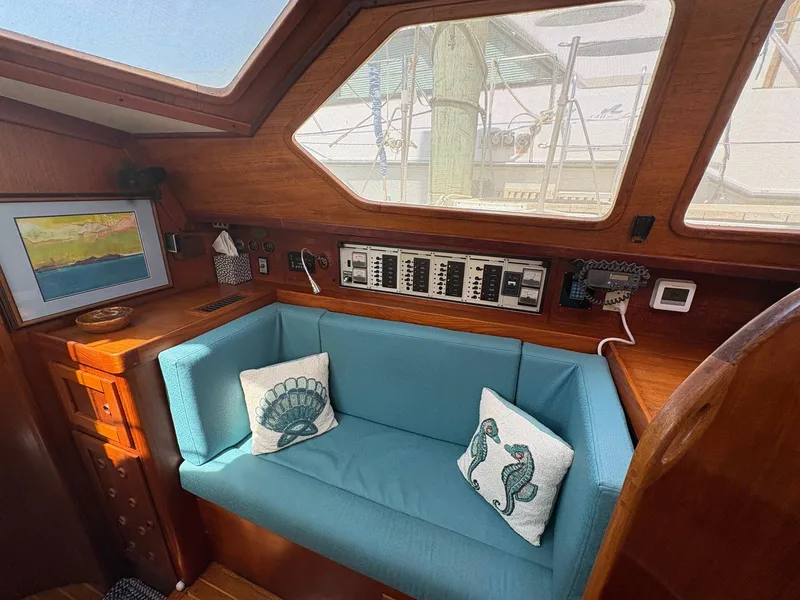 Slide: The Image of 1984 Freedom 39 Pilothouse interior with blue seating, nautical pillows, and control panel. - 12