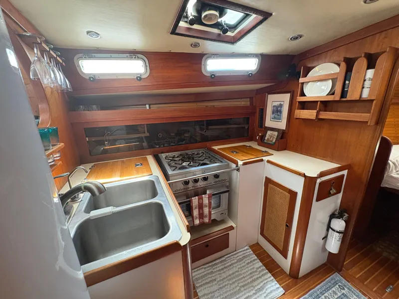 Slide: The Image of 1984 Freedom 39 Pilothouse yacht kitchen with stove, sink, and wooden cabinetry. - 15