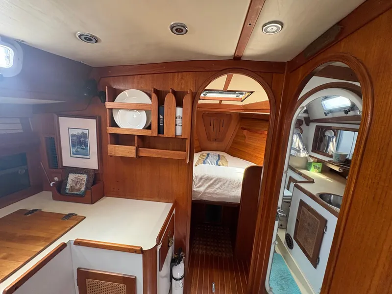 Slide: The Image of Cozy interior of 1984 Freedom 39 Pilothouse sailboat with wood finish and compact amenities. - 16