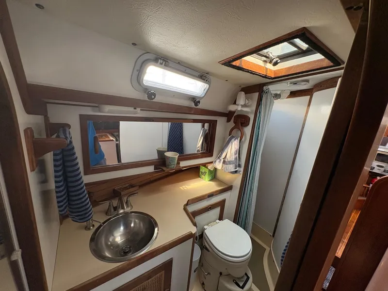 Slide: The Image of 1984 Freedom 39 Pilothouse bathroom with sink, toilet, mirror, and shower. - 17