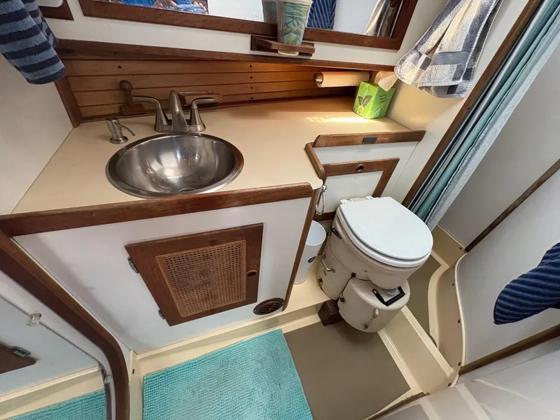 Slide: The Image of 1984 Freedom 39 Pilothouse bathroom with sink, toilet, and wooden accents. - 19