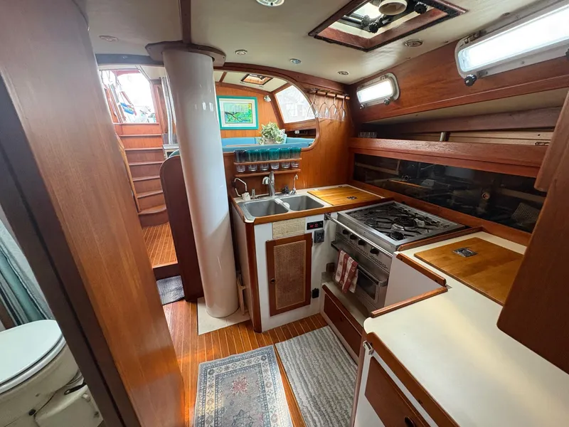 Slide: The Image of 1984 Freedom 39 Pilothouse yacht interior with kitchen, wooden cabinetry, and stairs. - 23