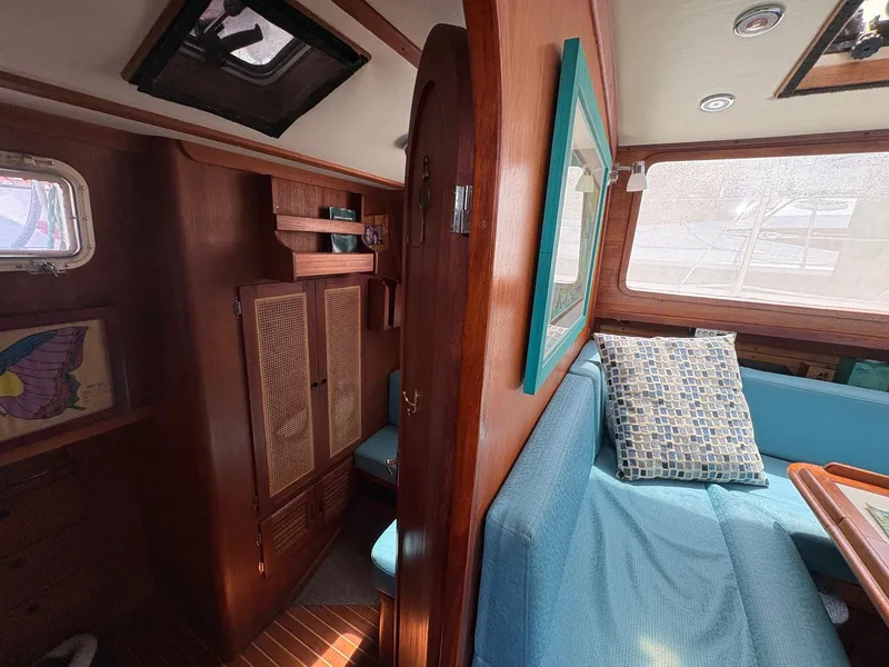 Slide: The Image of Interior of 1984 Freedom 39 Pilothouse with wooden cabinetry and blue seating. - 26