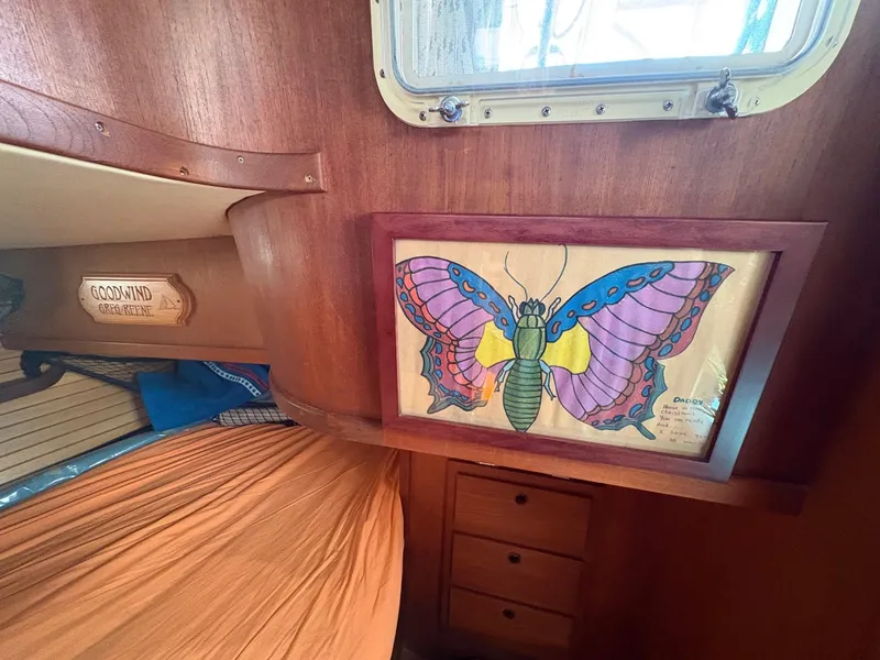 Slide: The Image of Interior of 1984 Freedom 39 Pilothouse with colorful butterfly artwork and wooden cabinetry. - 28