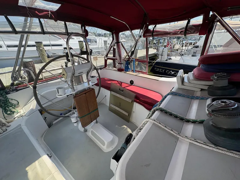 Slide: The Image of Interior view of 1984 Freedom 39 Pilothouse sailboat cockpit with red canopy and steering wheel. - 31