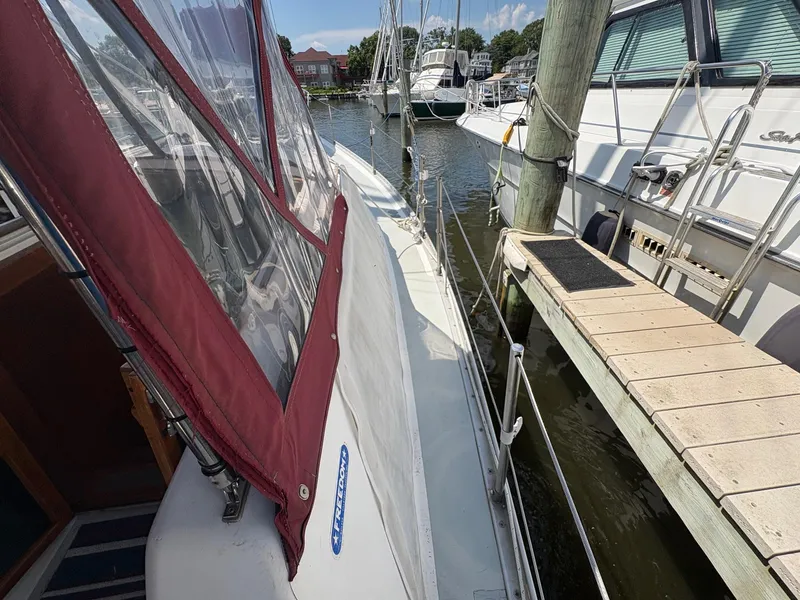Slide: The Image of 1984 Freedom 39 Pilothouse sailboat docked at marina with red canopy. - 34