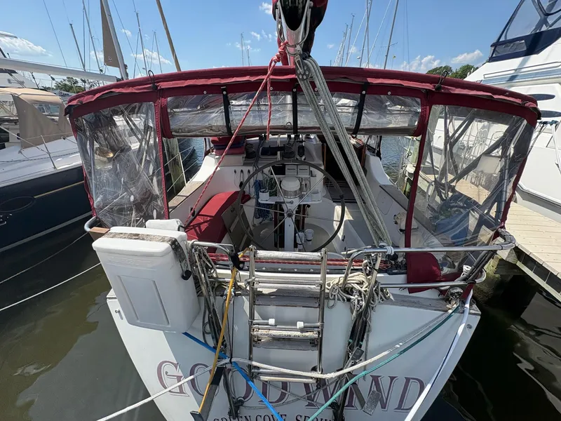 Slide: The Image of 1984 Freedom 39 Pilothouse sailboat docked, featuring a red canopy and nautical equipment. - 38