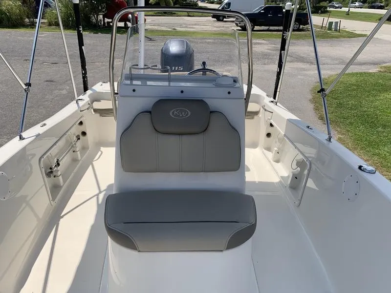 Slide: The Image of 2021 Key West 176cc boat interior with seating and console, parked outdoors. - 24