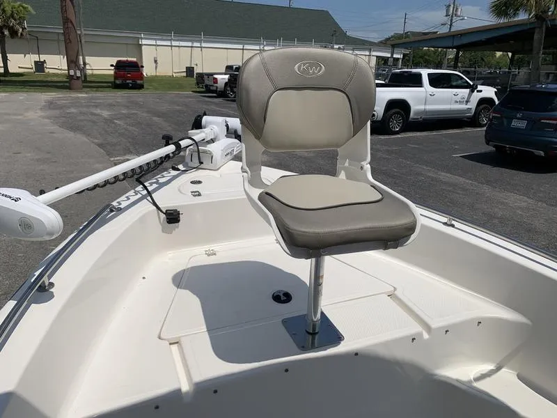 Slide: The Image of 2021 Key West 176cc boat with a cushioned seat and trolling motor in a parking lot. - 26
