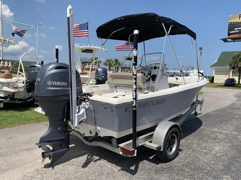 Slide: The Image of 2021 Key West 176cc boat with Yamaha motor on trailer, flags in background. - 4