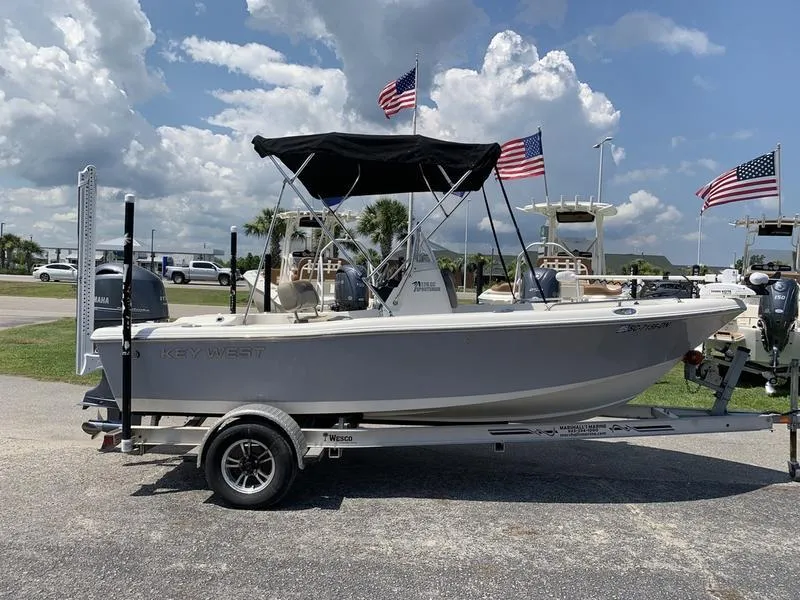 Slide: The Image of 2021 Key West 176cc boat on trailer, American flags, sunny day. - 5