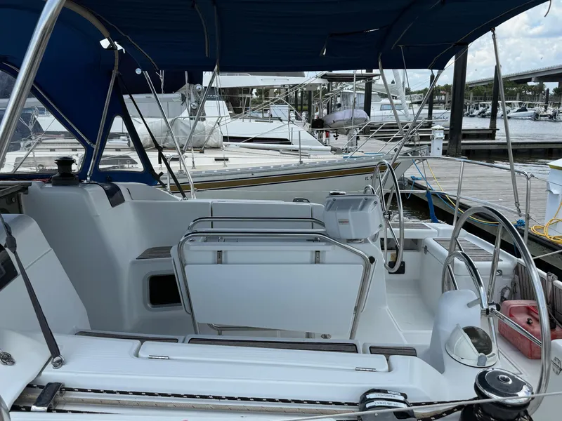 Slide: The Image of 2015 Jeanneau 409 sailboat cockpit with blue canopy, docked at marina. - 12